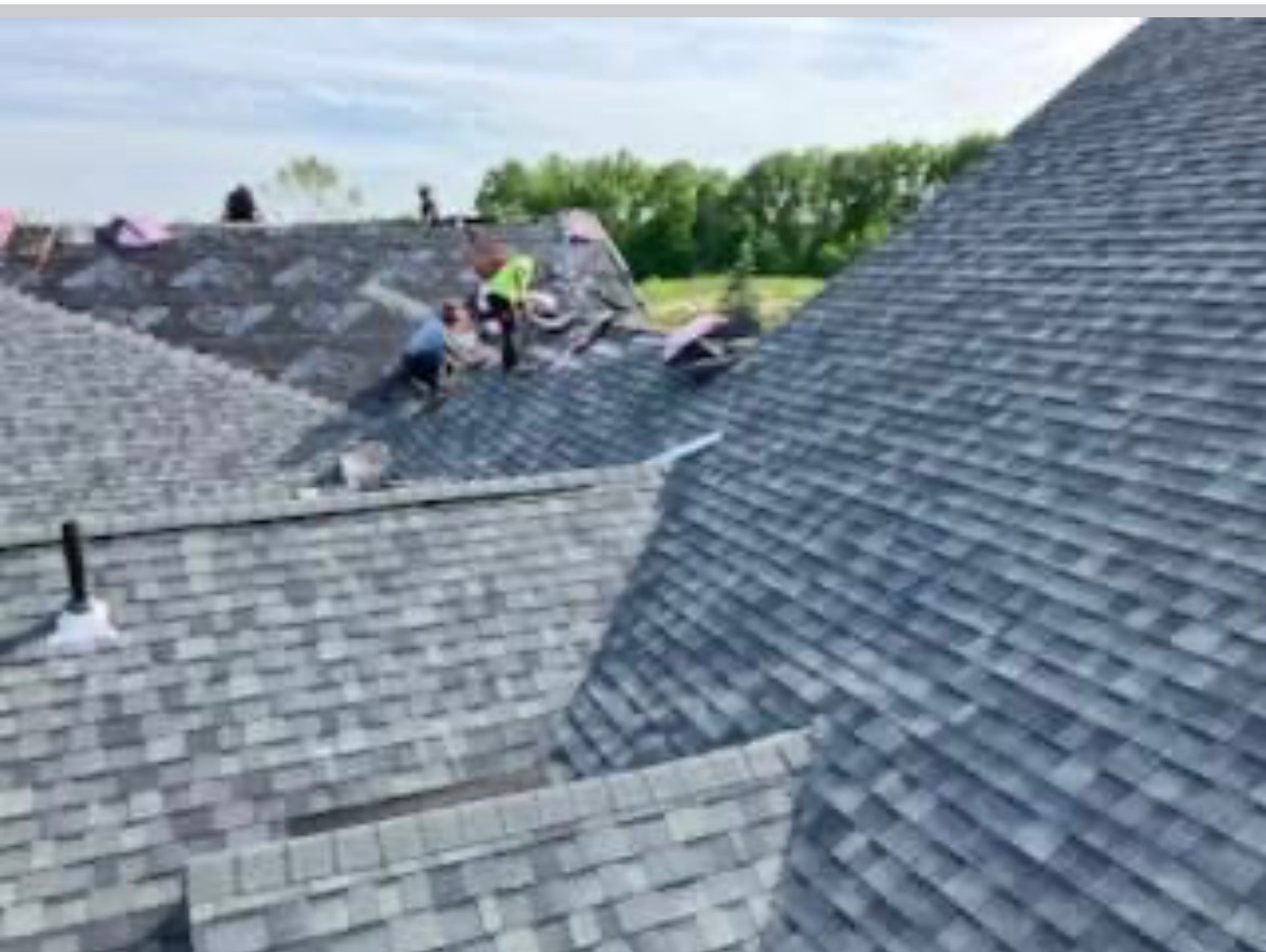 Roofing crew installing shingles